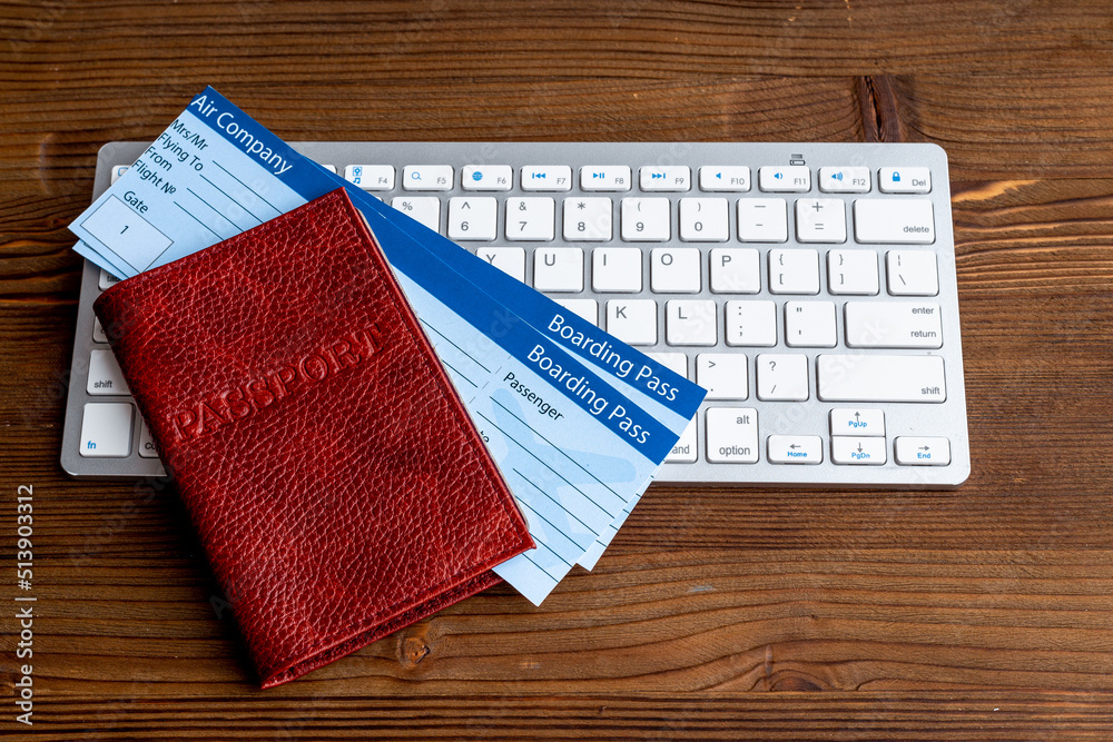 Fototapeta premium Booking air tickets concept. Passport with computer top view