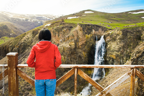 Young caucasian woman stand on viewpoint enjoy Susuz waterfall panorama outdoors on holiday photo