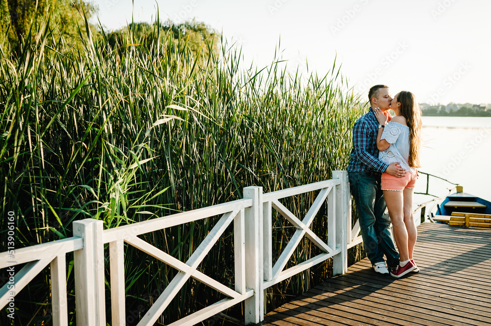 Couple hugging and kissing at sunset on pier. Couple hugging and kissing at sunset on pier.