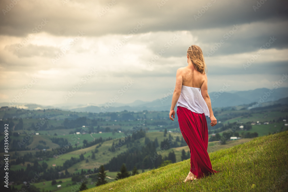 Woman in red at the green fields of Mountains Woman in red at the green fields of Mountains