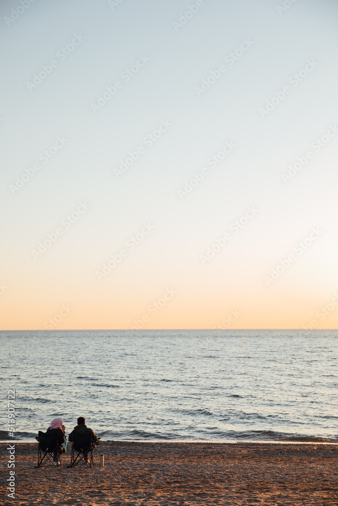 people relax picnic on the beach at sunset