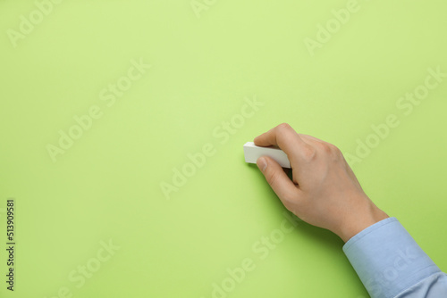 Man erasing something on green background, closeup. Space for text