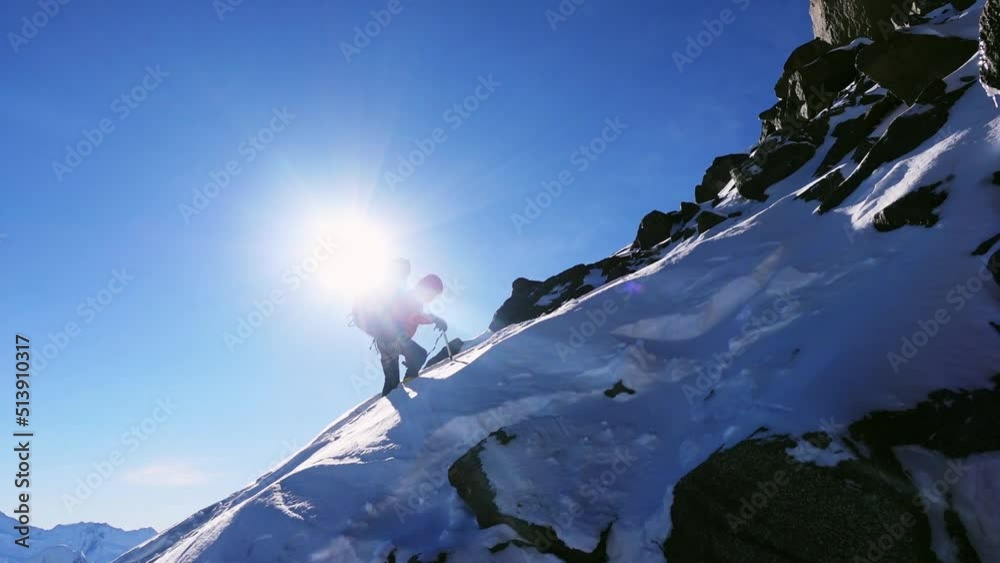 Equipped climber ascends the top of peak in snowy mountains self