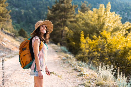 A woman with a backpack on a mountain path © zhukovvvlad