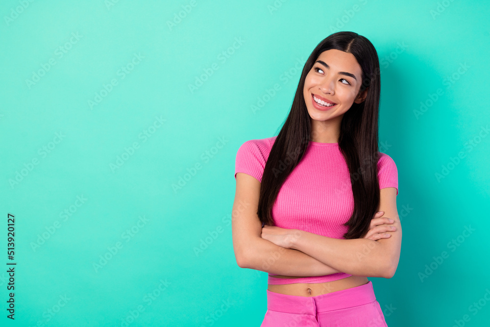 Photo of nice adorable lady look empty space with crossed hands wear outfit clothes isolated cyan color background Photo of nice adorable lady look empty space with crossed hands wear outfit clothes isolated cyan color background