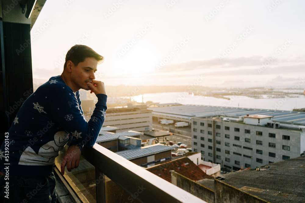 Man contemplating the city from a balcony
