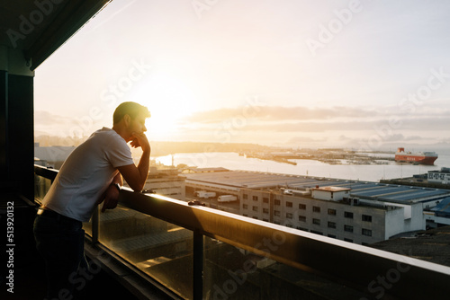 Man contemplating the city from a balcony © Ruben Chase