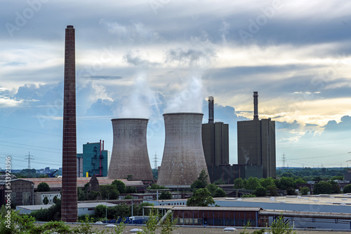 Towers and pollution of steel production industry in Duisburg with blast furnaces, coke oven and power plant against a cloudy sly with copy space