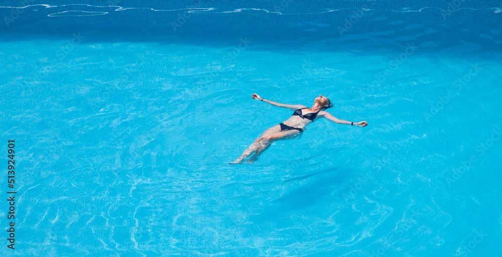 top view of woman floating in swimming pool