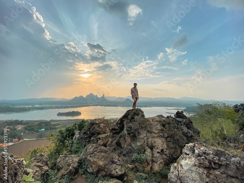 Adventure man with background of mountain view. Phu Sub Lek is hidden gem of Lopburi, Thailand to see view of Khao Jeen Lae with unseen sunset sky over the water from lake.