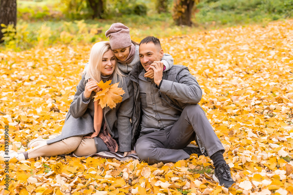 A Family of four enjoying golden leaves in autumn park A Family of four enjoying golden leaves in autumn park