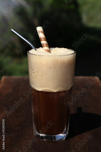 Close up of a stainless steel straw with iced coffee and a biscuit stick on a hot summer day. Completely without plastics and do not contain microplastics. Concept without plastic.