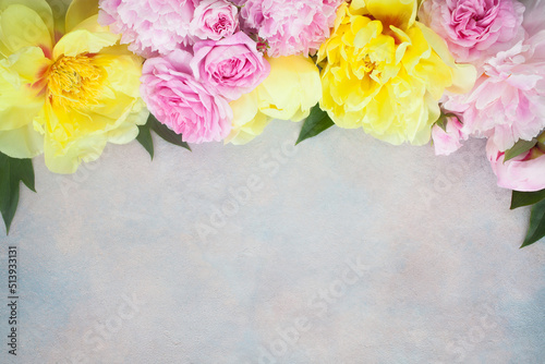 Pink and yellow peonies, pink roses on a colorful decorative background, space for text congratulations, invitations to a holiday, wedding