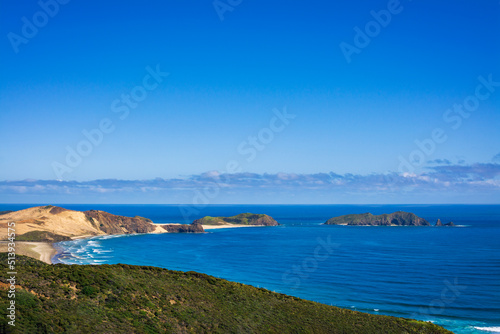 Stunning view from a high vantage point at Te Werahi Beach and Cape Maria Van Diemen. Vivid blue sea of the Tasman Sea and clear sky of a bright winter day. Cape Reinga, North Island, New Zealand