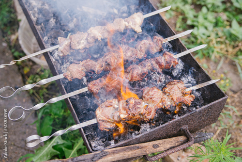 Fresh meat for barbecue, fried on fire. Selective focus. Grilled lamb meat. Cooking barbecue on the grill with smoke. Picnic in nature. Healthy food and proper nutrition.