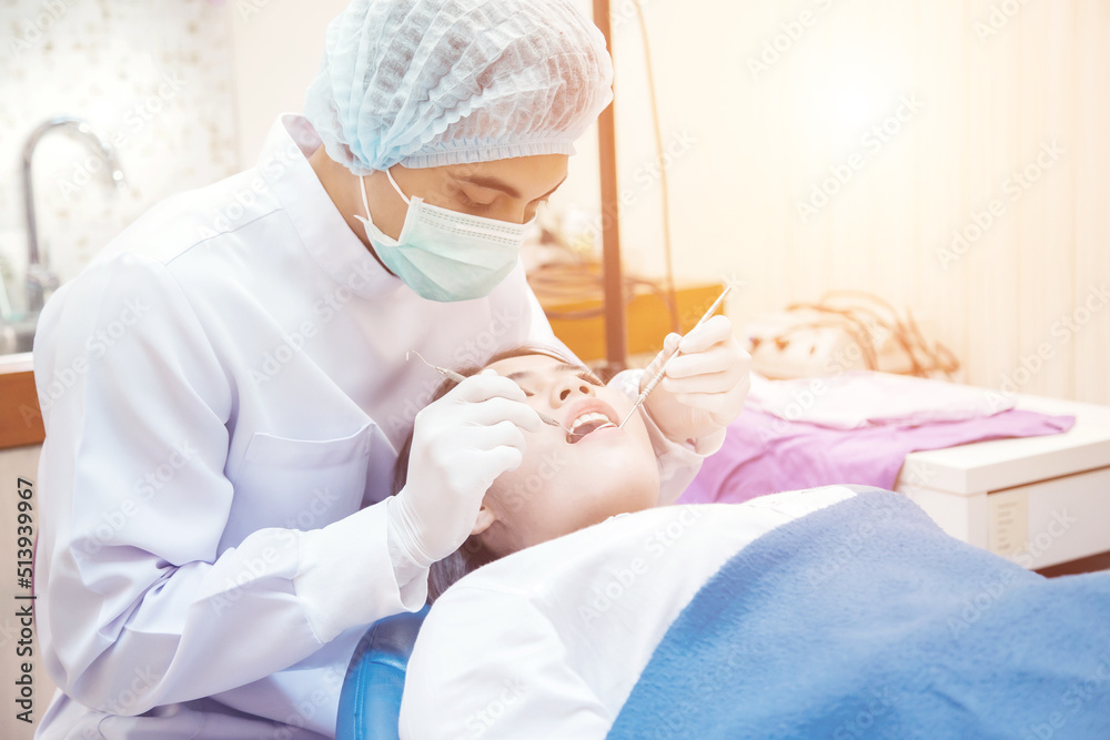 Naklejka premium Young man dentist who treats teeth of young woman patient.
