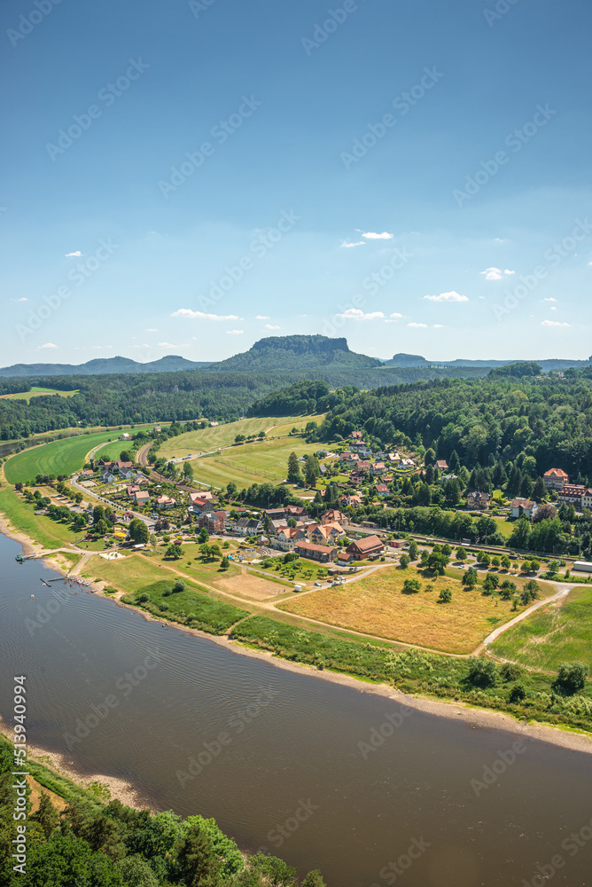Cover page with birdview over Lilienstein table like sandstone pillar, Bastei rocks near Kurort Rathen village in the national park Saxon Switzerland and Elbe river with blue sky, Saxony, Germany.