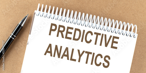 Fotografie Predictive Analytics text on a notepad with pen, business