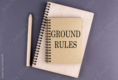 Word GROUND RULES on notebook with pencil on the grey background