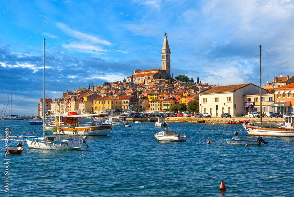 Beautiful view of the harbor with boats, yachts and a old town buildings, Campanile of Saint Euphemia Church of Rovinj city against a blue sky in sunny day. Rovinj, Istria, Croatia