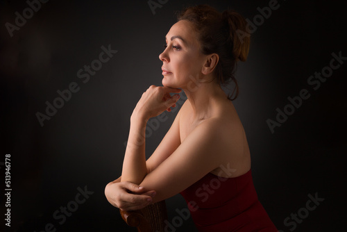 portrait of a sensual fifty year old woman on grey studio background