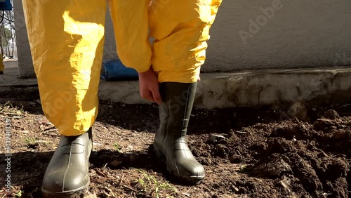 Introductory video showing the yellow farmer's overalls being put on the foot. Black boots and yellow overalls. photo