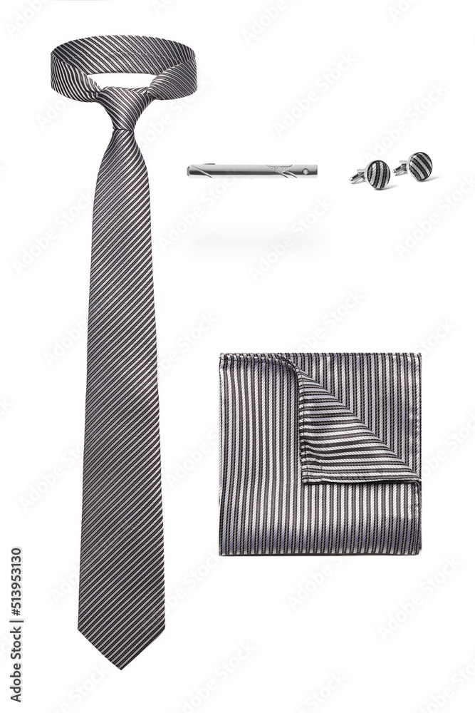 Close-up set of a gray and white stripe tie, a gray and white striped pocket square, fabric covered cufflinks and a metallic tie clip. Men's accessories are isolated on a white background. Front view. Close-up set of a gray and white stripe tie, a gray and white striped pocket square, fabric covered cufflinks and a metallic tie clip. Men's accessories are isolated on a white background. Front view.