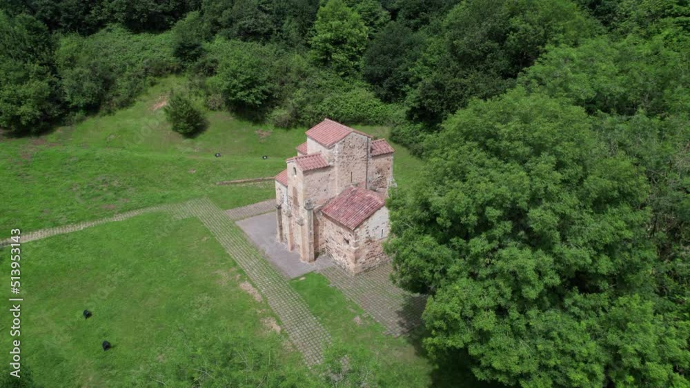 Well-preserved pre-Romanesque church in the middle of a natural green landscape seen from above. Well-preserved pre-Romanesque church in the middle of a natural green landscape seen from above.