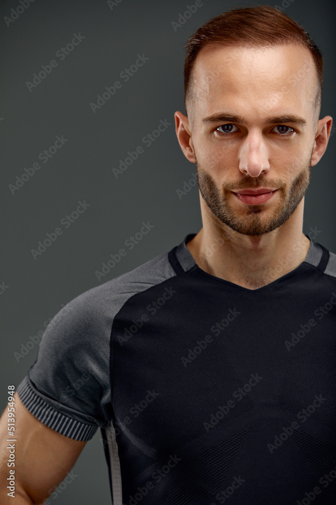Croped portrait of male fitness model in black top relaxing after workout. Grey background with room for text, Copy space. Croped portrait of male fitness model in black top relaxing after workout. Grey background with room for text, Copy space.