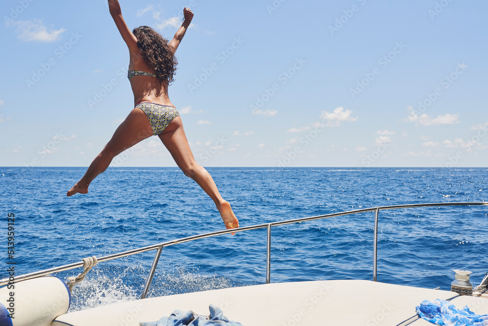 Full length shot of an unrecognisable woman jumping off a boat during