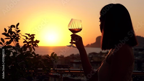 Happy woman hold wineglass and leisure drinking wine. Silhouette of pretty lady relaxing leisure celebrating weekend vacation and enjoys the sunset view. 4k footage