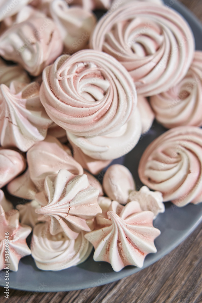 pink meringues on a plate of different shapes. sweets and decoration for a birthday cake pink meringues on a plate of different shapes. sweets and decoration for a birthday cake