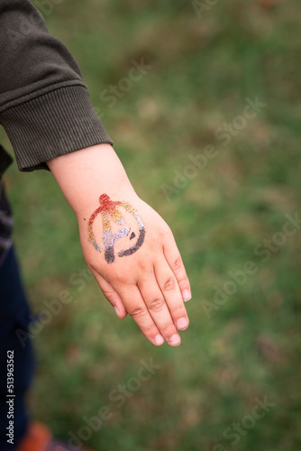 Shimmering sparkling glitter tattoo on a child's hand at a birthday party