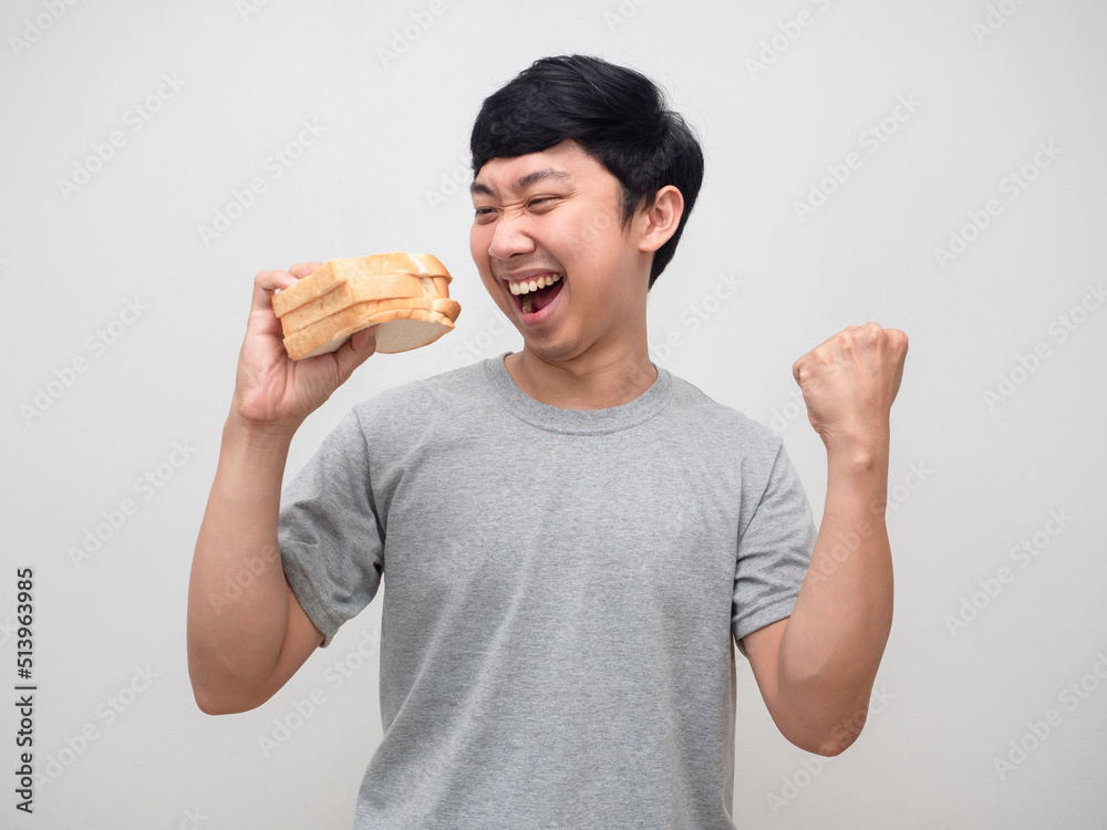 Young man happy gesture fist up about eatting sandwich in hand Young man happy gesture fist up about eatting sandwich in hand