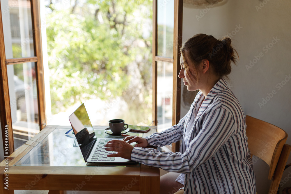 Happy young businesswoman sitting at table with laptop next to window. Skilled manager saleswoman calling customer, giving professional consultation. Happy young businesswoman sitting at table with laptop next to window. Skilled manager saleswoman calling customer, giving professional consultation.