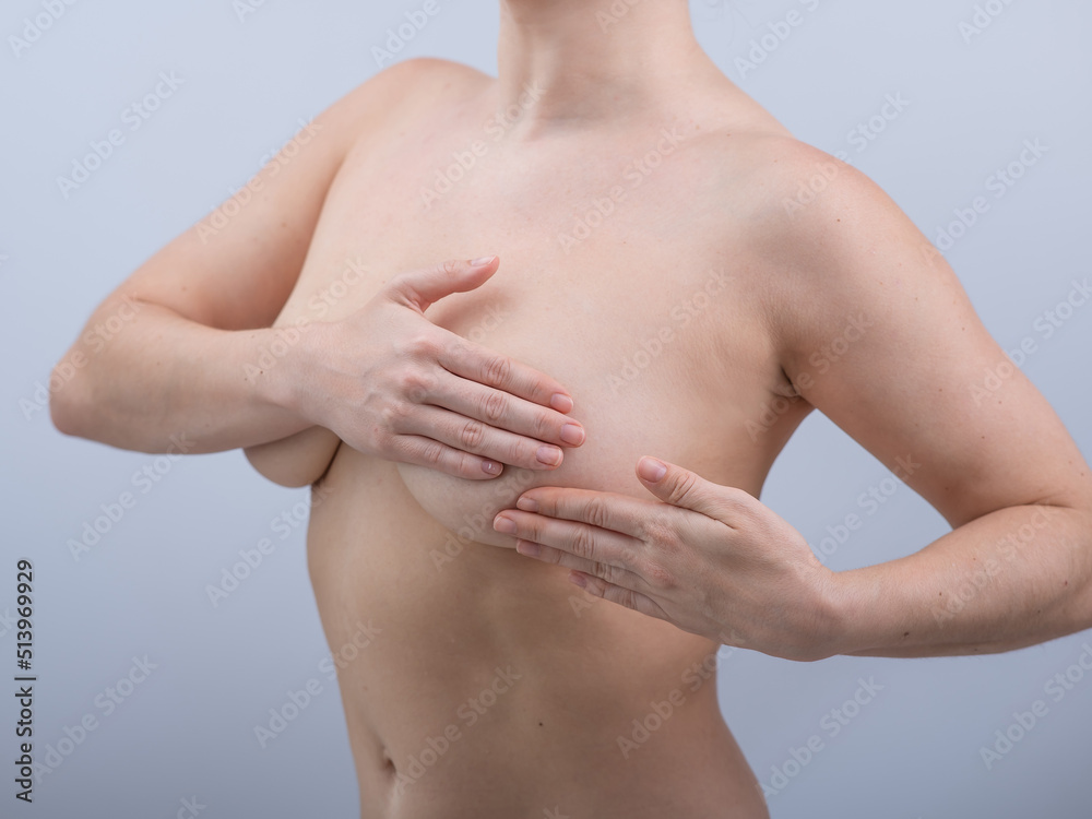 Caucasian woman self checks for breast cancer on white background. Caucasian woman self checks for breast cancer on white background.