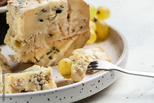 Danish blue cheese. Tasty blue cheese on a wooden background and burlap. Dorblu cheese pieces. Food recipe background. Close up