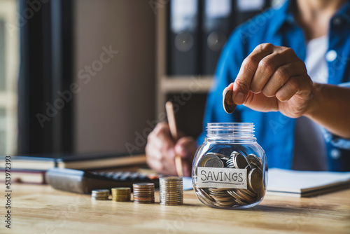 housewife puts a coin in a jar to save money for the future. after retirement and record keeping of income, expenditure, savings and financial concepts.