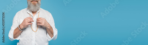 cropped view of spiritual guru meditating and touching beads isolated on blue, banner.