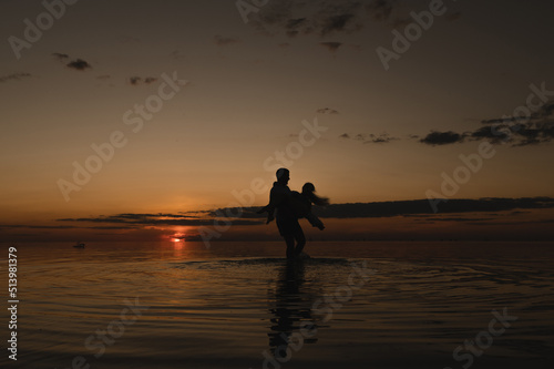 Romantic couple on the background of sunset near the ocean. Sunset walk along the ocean © flywish