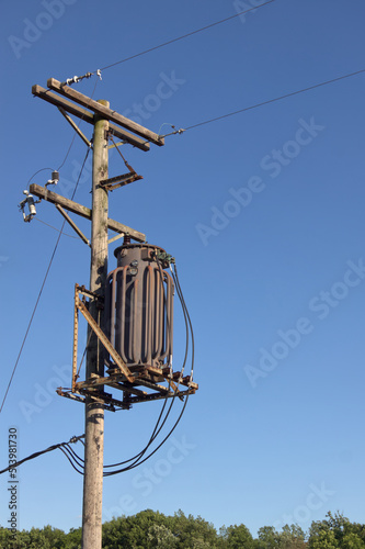 Vertical frame of a utility pole against a clear blue sky