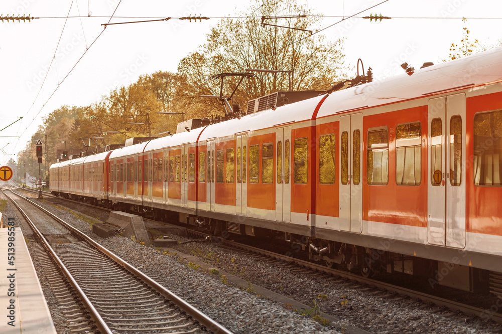 Train on Railway Station. Modern High Speed Red Commuter Electric Train with motion in Germany