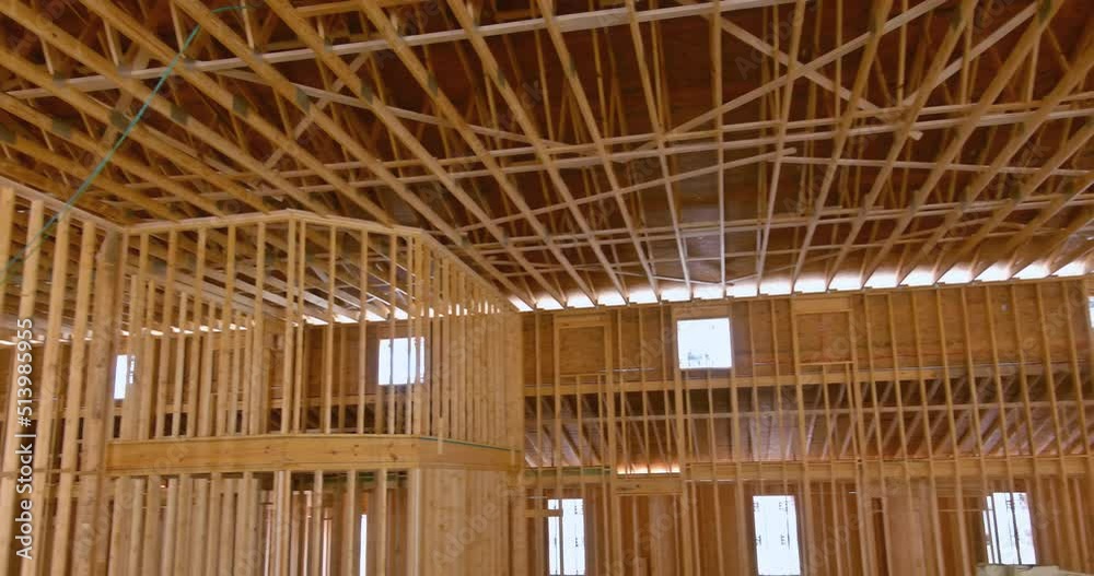 An interior view of a wooden building the beam framework is supported by wooden truss rafters on top beams An interior view of a wooden building the beam framework is supported by wooden truss rafters on top beams