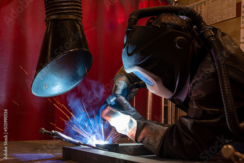 Workers wearing industrial uniforms and Welded Iron Mask at Steel welding plants, industrial safety first concept.