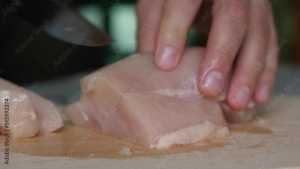 Close Up Chicken Fillet on Cut Board. Man` Hands Knife Slices Delicate Turkey Fillet on Wooden Cut Board. Cook Cuts Chicken Breast, Raw White Meat, Chef Cooks Chicken Breasts, Diet Healthy Eating. Close Up Chicken Fillet on Cut Board. Man` Hands Knife Slices Delicate Turkey Fillet on Wooden Cut Board. Cook Cuts Chicken Breast, Raw White Meat, Chef Cooks Chicken Breasts, Diet Healthy Eating.