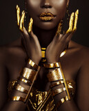 art fantasy portrait african american woman. female hands close-up, fingers in golden paint. Girl queen Cleopatra style. greek gold bracelets. Creative metallic professional makeup lips diamonds gloss