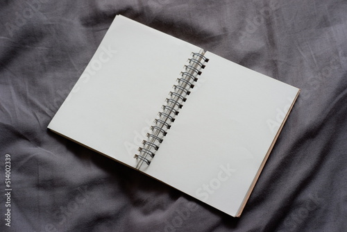 Notebook, open two pages, placed on cloth, top view.