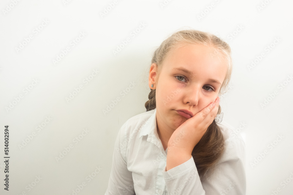 Little girl wearing white shirt is having toothache or feeling sad and worried Little girl wearing white shirt is having toothache or feeling sad and worried