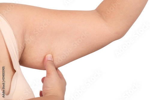 Fat woman using her finger to catch excess fat under her arms, which has a flabby appearancd, On white isolated background, to health woman and excess fat concept. photo