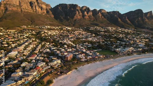 South African skyline of Camps Bay with 12 Apostles in background at sunset, aerial
